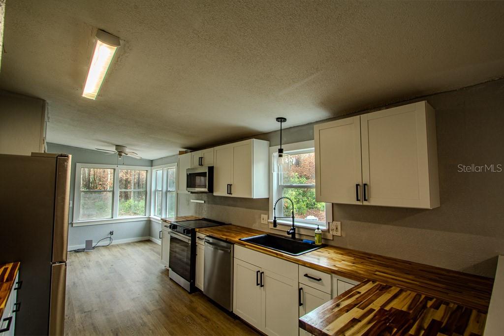 448 Southwest Central Terrace Fort White, FL 32038 - Photo 7 of 19 a kitchen with stainless steel appliances a sink cabinets and wooden floor
