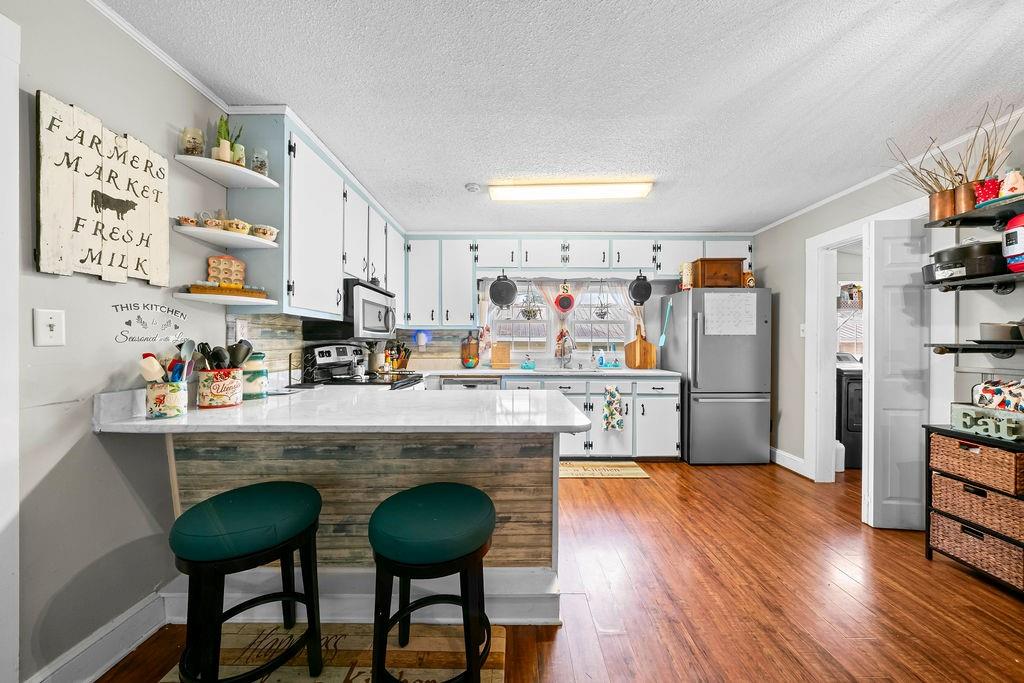 1763 Burnett Ferry Road Southwest Rome, GA 30165 - Photo 7 of 31 a kitchen with stainless steel appliances granite countertop a table chairs refrigerator and sink