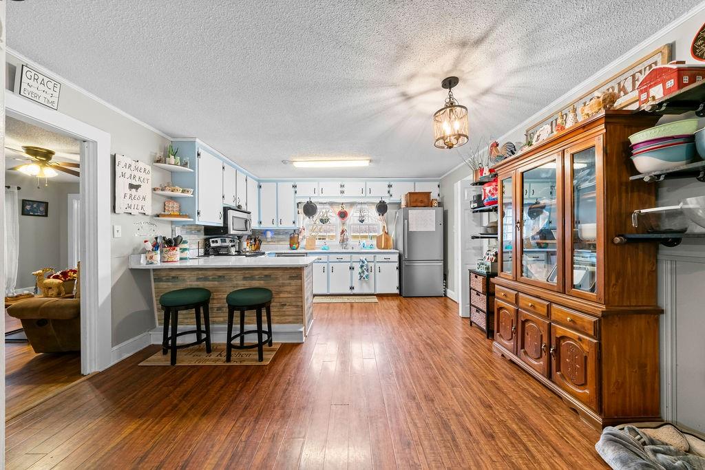 1763 Burnett Ferry Road Southwest Rome, GA 30165 - Photo 9 of 31 a kitchen with stainless steel appliances granite countertop a refrigerator a stove top oven a dining table and chairs with wooden floor