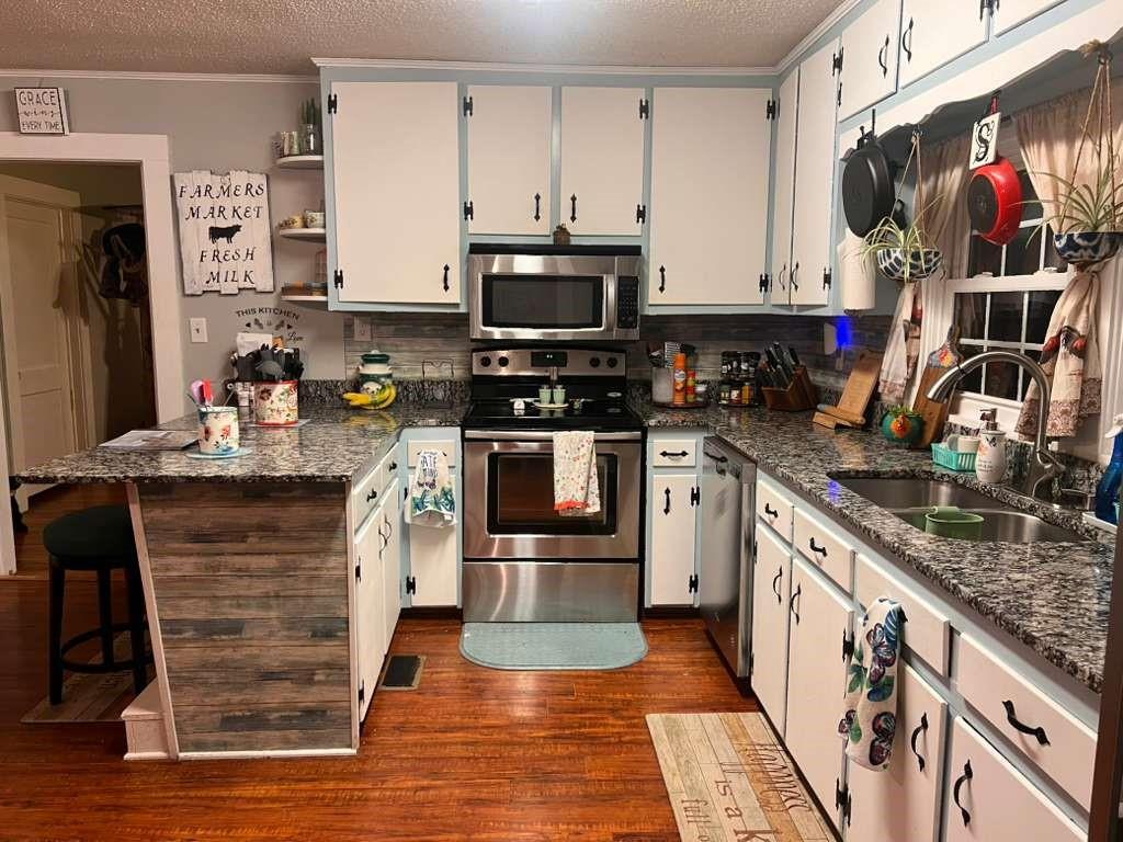 1763 Burnett Ferry Road Southwest Rome, GA 30165 - Photo 10 of 31 a kitchen with stainless steel appliances granite countertop a stove top oven a sink dishwasher and a microwave oven with large wooden cabinets