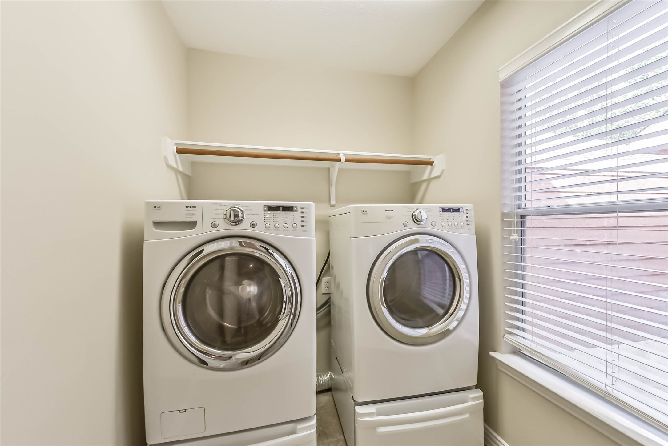 30910 Blue Ridge Park Lane Spring, TX 77386 - Photo 42 of 50 Bright and functional laundry room featuring a modern washer and dryer, complemented by a convenient shelving unit and a large window for natural light.