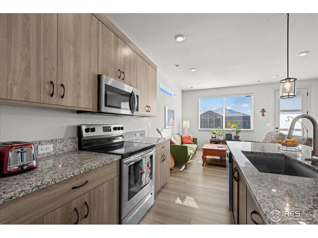 1088 Blue Bell Road Berthoud, CO 80513 - Photo 16 of 33 a kitchen with stainless steel appliances granite countertop a sink dishwasher stove and microwave with wooden cabinets