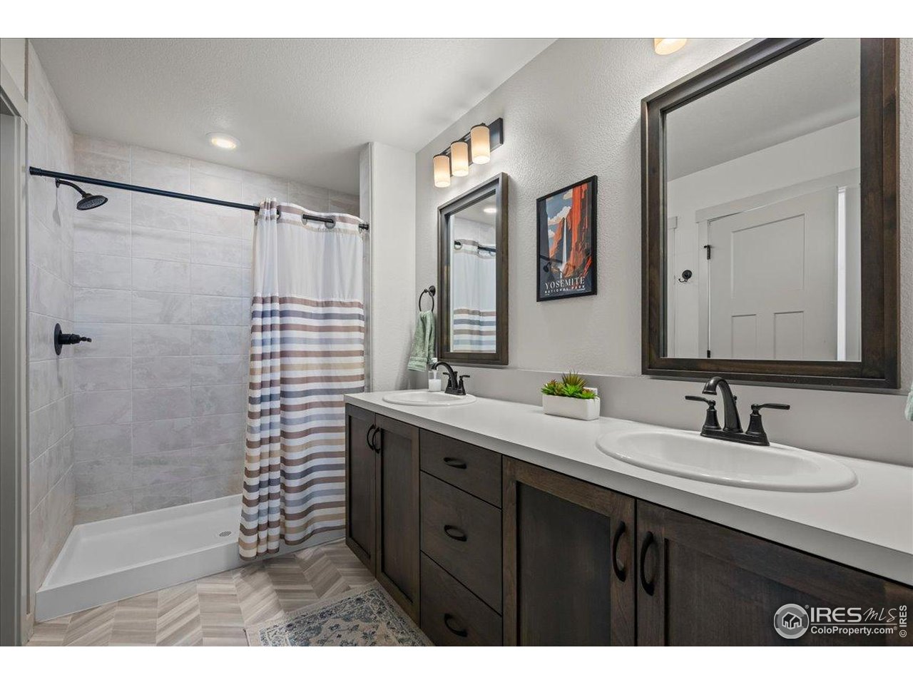 1088 Blue Bell Road Berthoud, CO 80513 - Photo 20 of 33 a bathroom with a double vanity sink mirror and shower