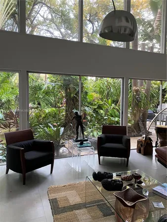 a living room with furniture and a floor to ceiling window