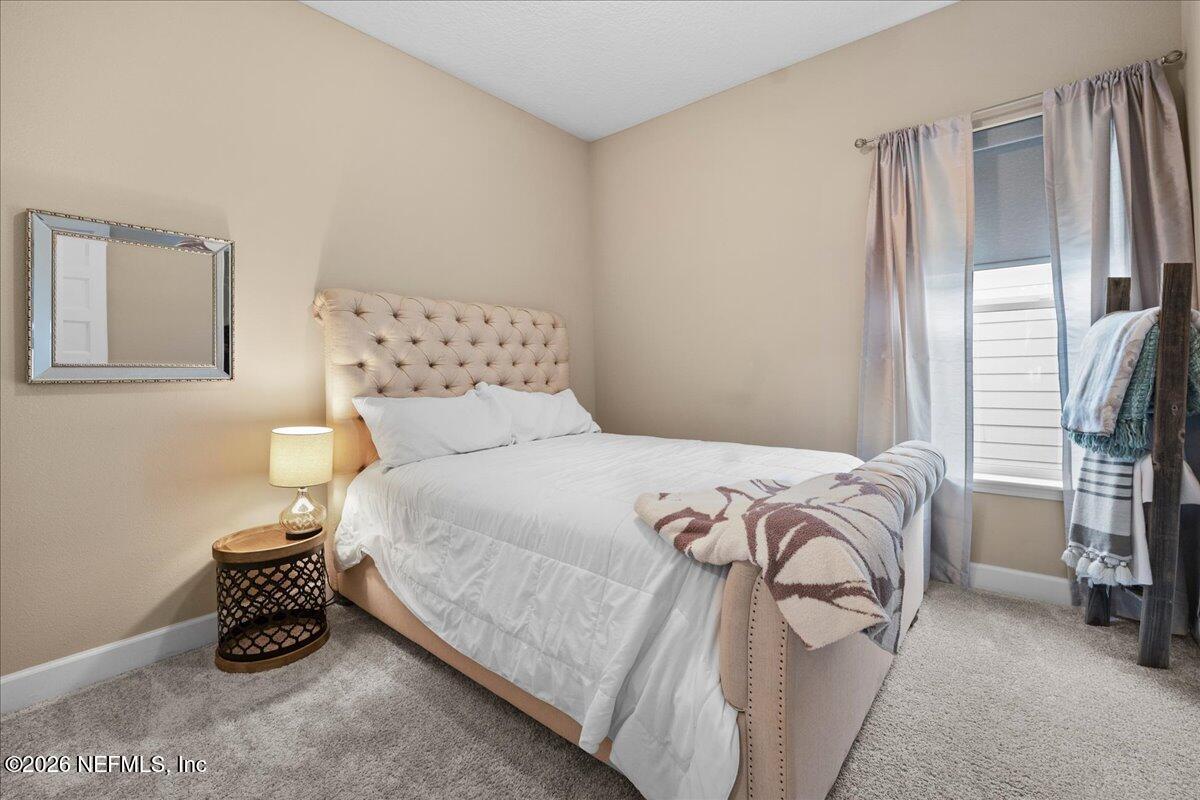 11098 Engineering Way Jacksonville, FL 32256 - Photo 23 of 62 a bedroom with a bed and a chandelier