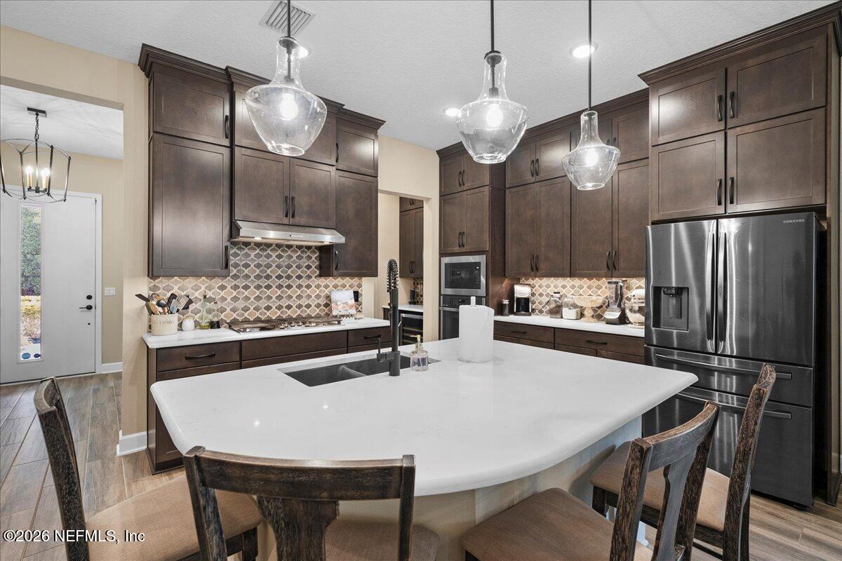 11098 Engineering Way Jacksonville, FL 32256 - Photo 10 of 62 a kitchen with stainless steel appliances kitchen island a table and chairs