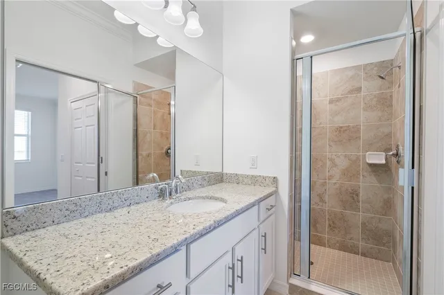 a bathroom with a granite countertop sink a mirror and a shower