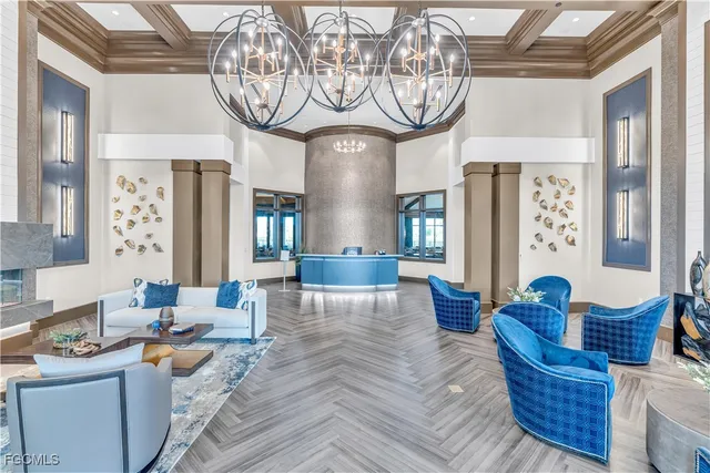 a living room with furniture a chandelier and a large mirror