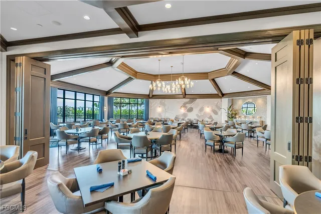 a outdoor space with lots of tables a large window and chairs