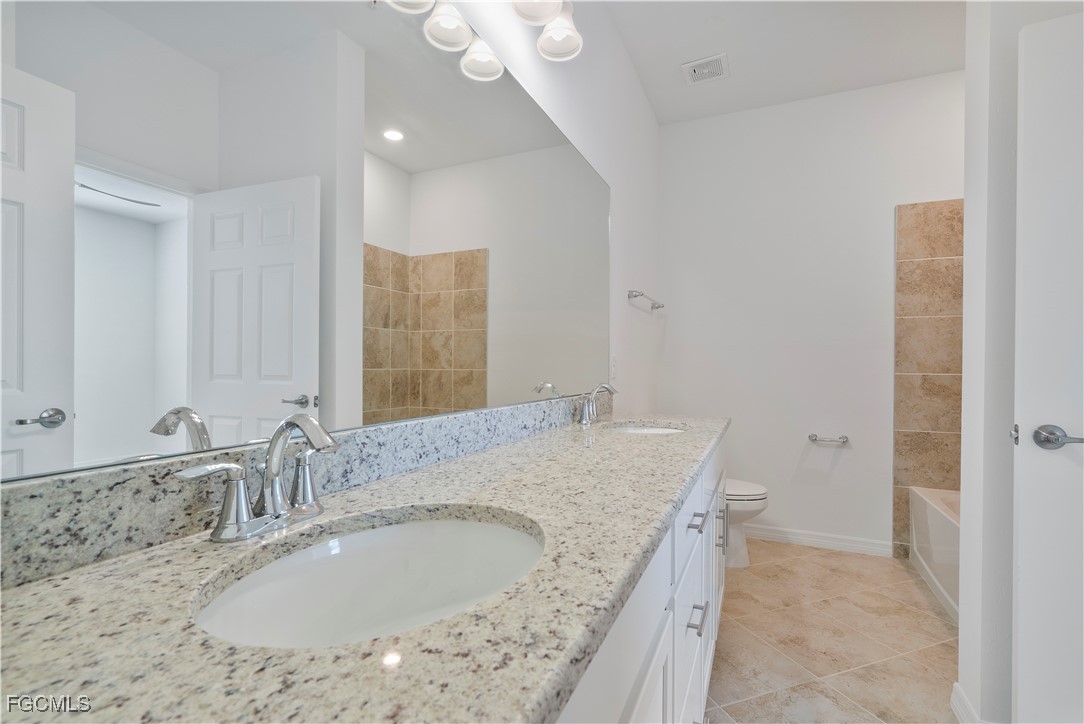 43977 Boardwalk Loop, Unit 2338 Punta Gorda, FL 33982 - Photo 4 of 50 a bathroom with a granite countertop sink and a mirror