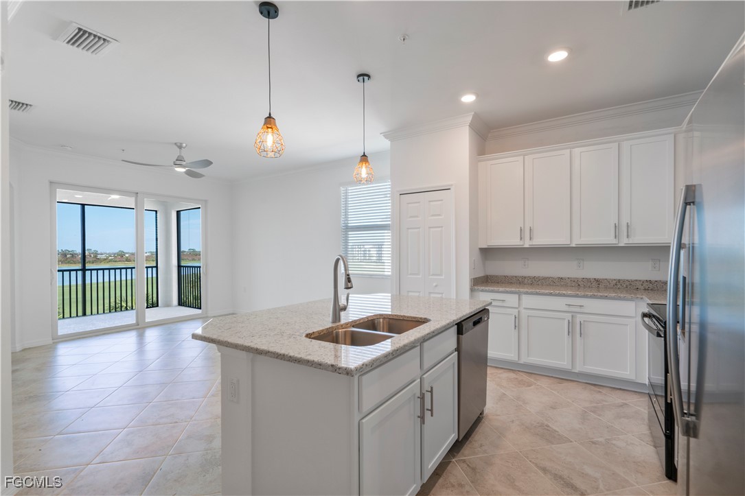 43977 Boardwalk Loop, Unit 2338 Punta Gorda, FL 33982 - Photo 6 of 50 a kitchen with kitchen island granite countertop a sink a counter top space and stainless steel appliances