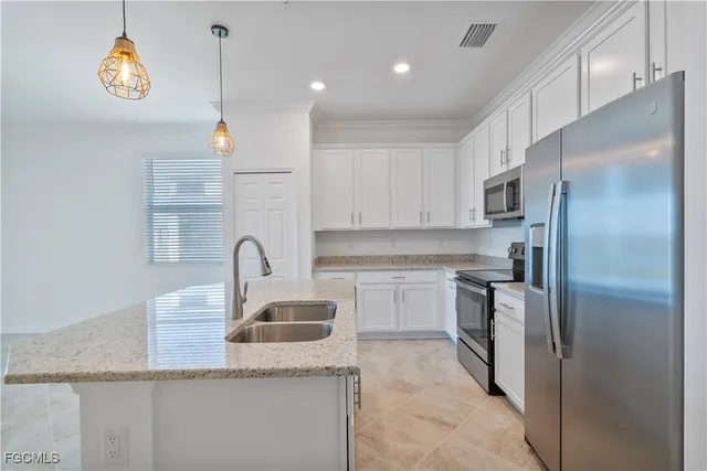 a kitchen with kitchen island granite countertop a sink stainless steel appliances and cabinets