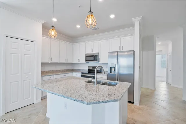 a kitchen with kitchen island granite countertop a sink center island and stainless steel appliances