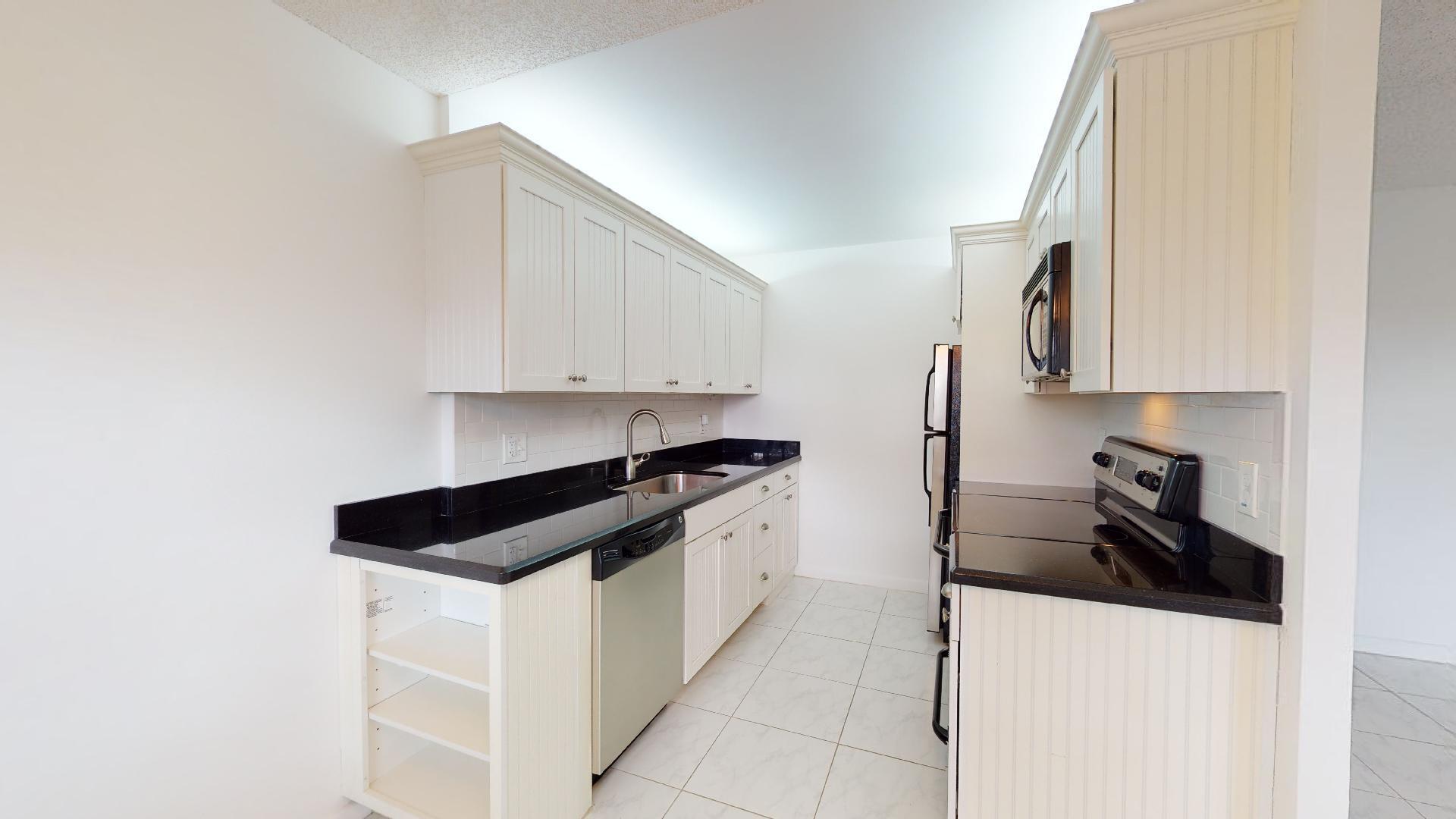 1014 Exeter Boca Raton, FL 33434 - Photo 15 of 31 a kitchen with stainless steel appliances a sink a stove and a refrigerator