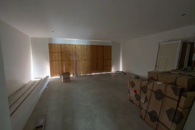 a large kitchen with stainless steel appliances granite countertop a refrigerator a sink dishwasher a dining table and chairs with wooden floor