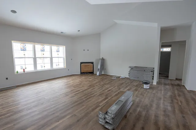 an empty room with windows and wooden floor