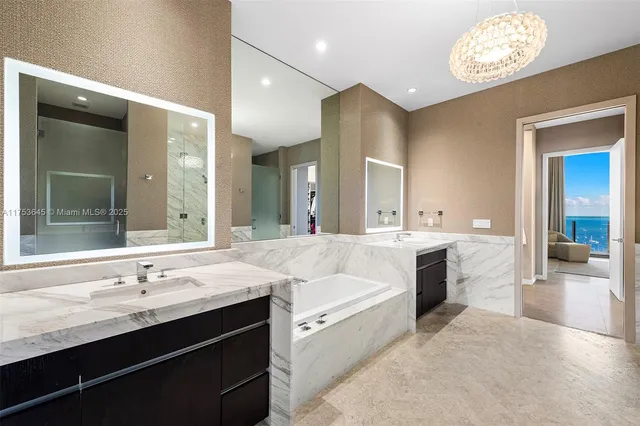 a bathroom with a granite countertop sink mirror and a bathtub
