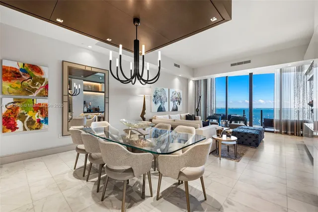 a living room with furniture a chandelier and a large window
