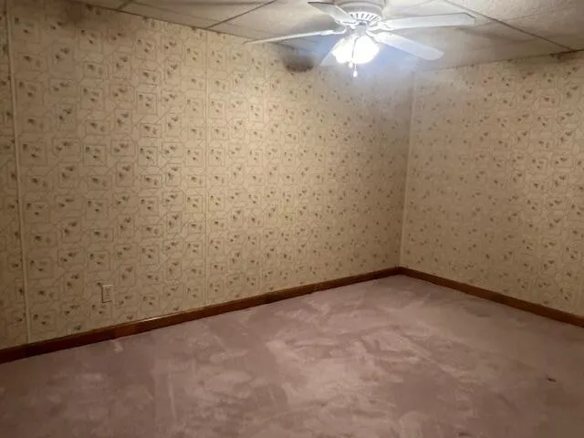an empty room with a chandelier fan