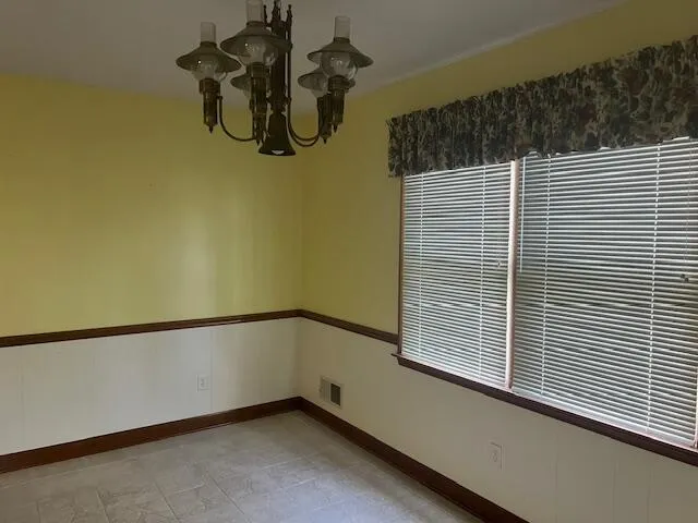 an empty room with a chandelier fan