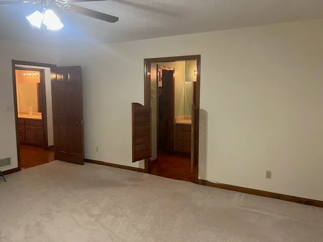 an empty room with fireplace and fan