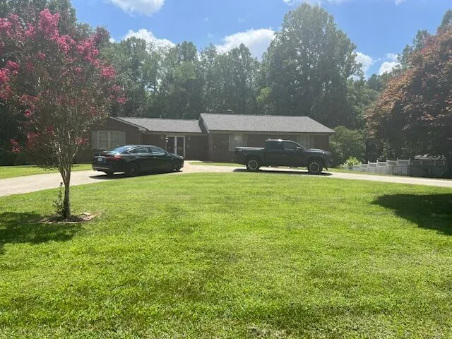 a view of a house with a yard and sitting area