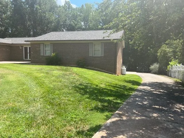 a front view of a house with yard and green space