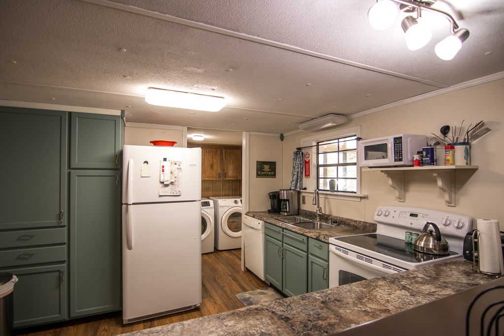 1631 West Pine Lake Drive West Point, GA 31833 - Photo 16 of 37 a kitchen that has a refrigerator and a sink