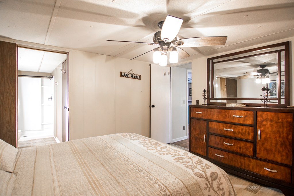 1631 West Pine Lake Drive West Point, GA 31833 - Photo 18 of 37 a bedroom with a bed and a chandelier