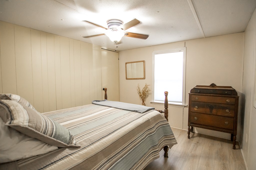 1631 West Pine Lake Drive West Point, GA 31833 - Photo 22 of 37 a bedroom with a bed and a chandelier