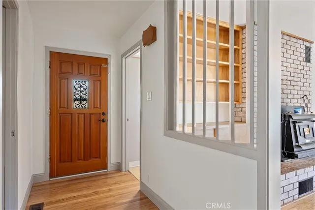 a view of empty room with wooden floor and fireplace