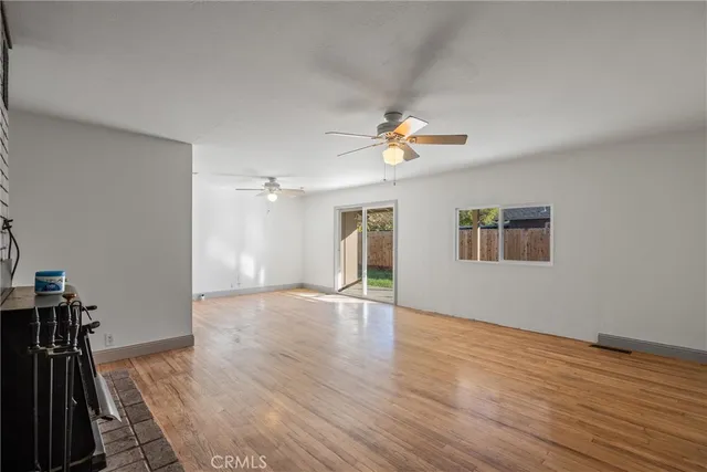 a view of empty room with a fireplace and wooden floor