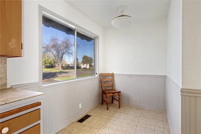 a view of an empty room with window and a ceiling fan