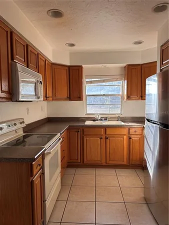 a kitchen with a sink a stove top oven and cabinets