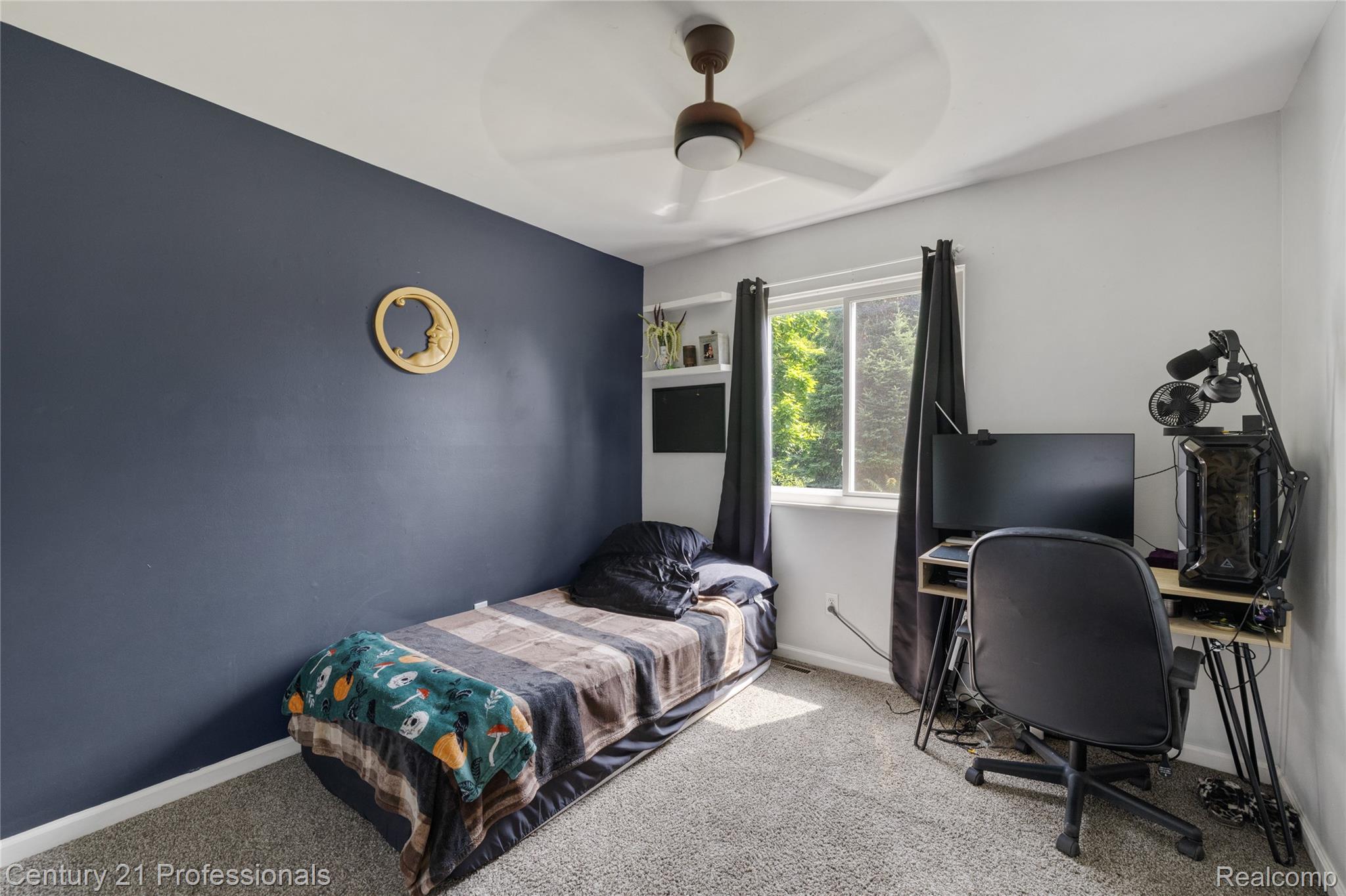 15037 Hogan Road Linden, MI 48451 - Photo 25 of 38 Carpeted room featuring a ceiling fan with light, a window with exterior views, and a feature wall