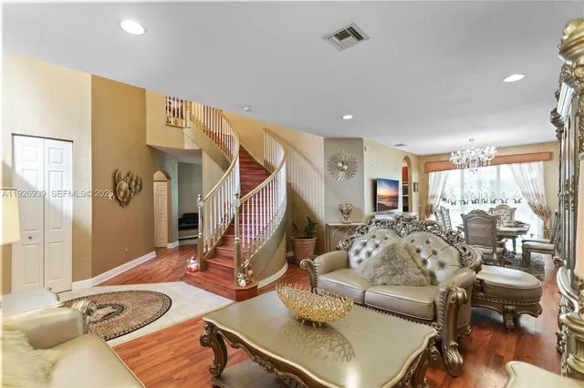 a view of a dining room with furniture a chandelier and wooden floor