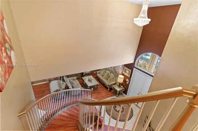 a living room with furniture floor to ceiling window and wooden floor