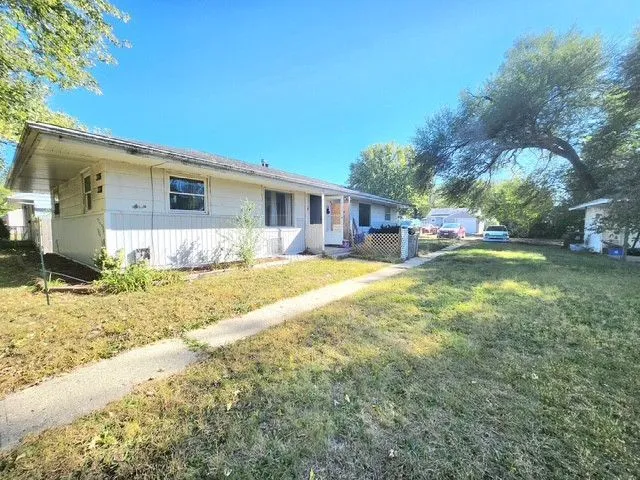 a view of a house with a yard and sitting area