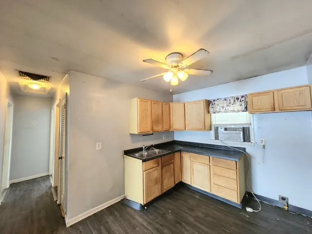 a kitchen with granite countertop a stove a sink and a refrigerator