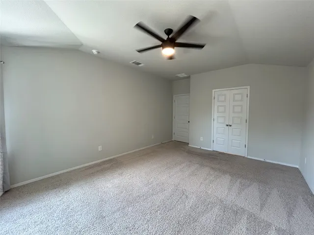 a view of a livingroom with a ceiling fan and windows
