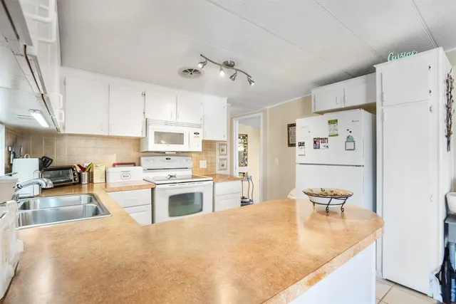 a kitchen with granite countertop a sink stove and refrigerator