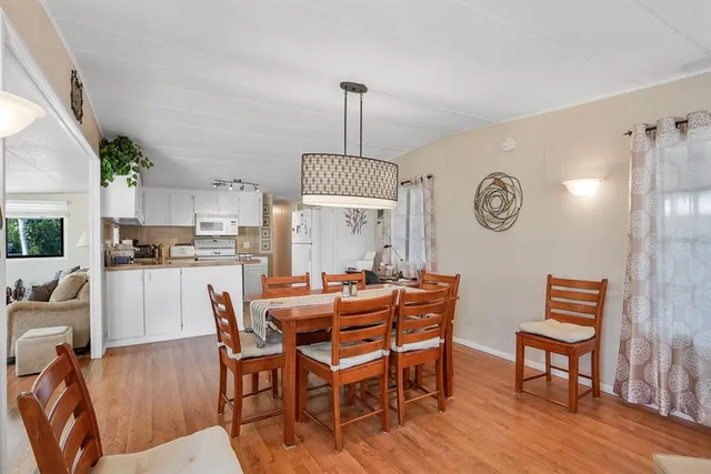 a dining room with furniture a chandelier and wooden floor