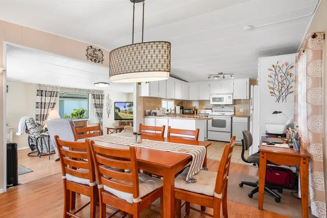 a dining room with furniture a kitchen and chandelier