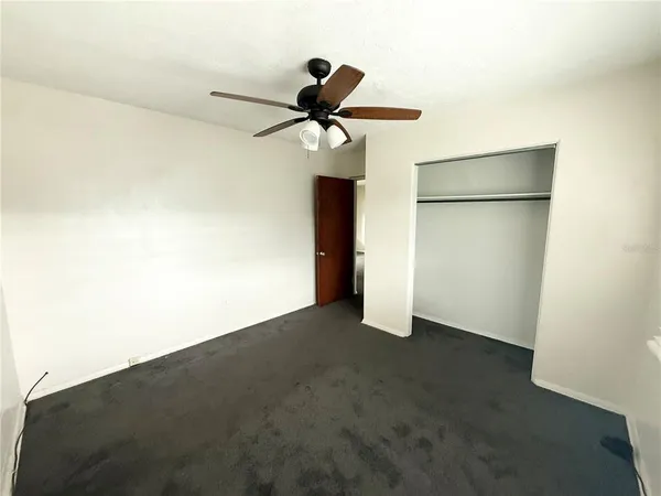 an empty room with closet and windows