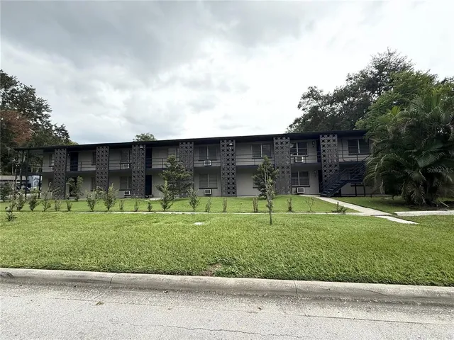 a view of a house with brick walls and a yard with plants