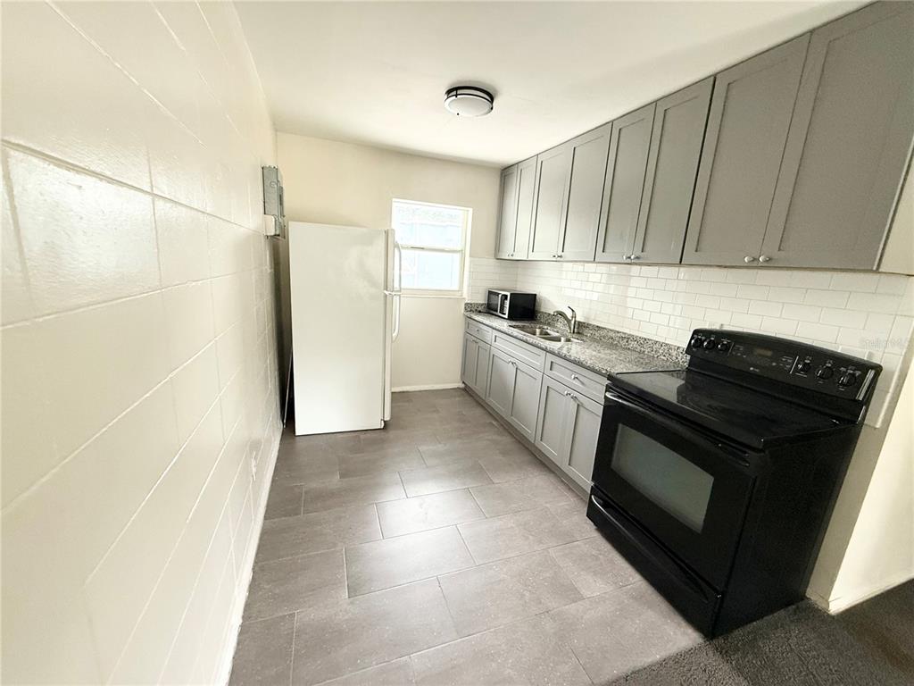 639 Ramona Lane, Unit 6 Orlando, FL 32805 - Photo 6 of 18 a kitchen with a stove top oven and cabinets