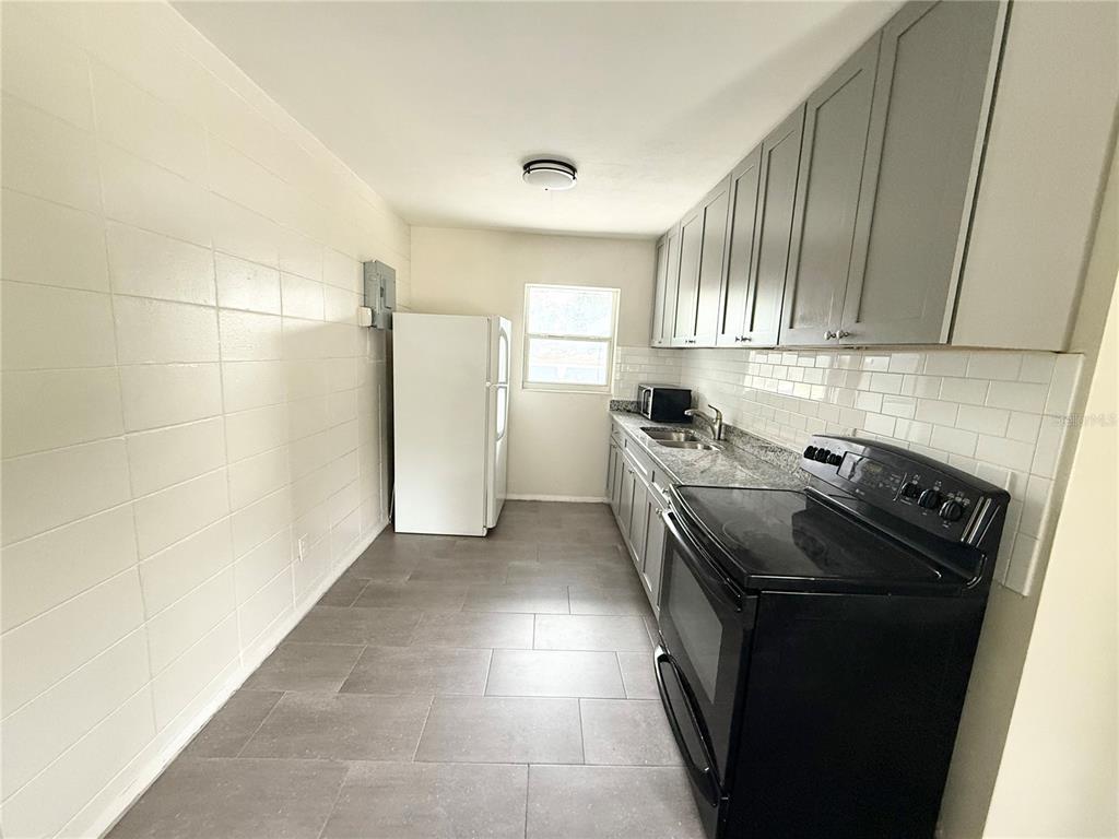 639 Ramona Lane, Unit 6 Orlando, FL 32805 - Photo 7 of 18 a kitchen with a refrigerator and a stove
