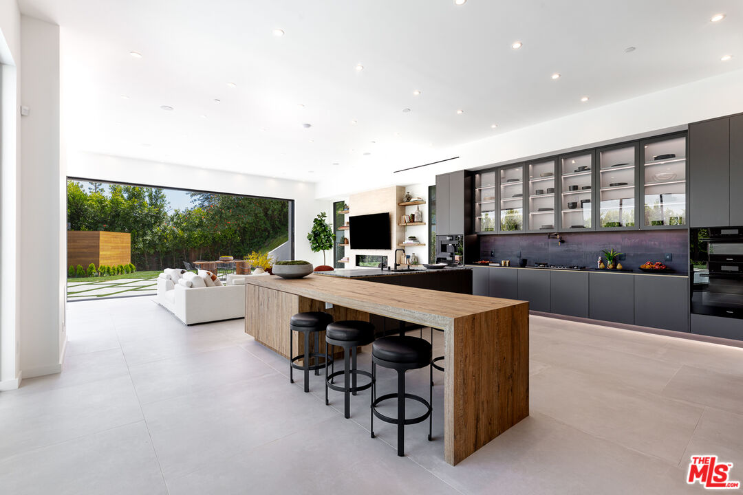 1523 Stradella Road Los Angeles, CA 90077 - Photo 29 of 54 a living room with furniture a flat screen tv and a floor to ceiling window