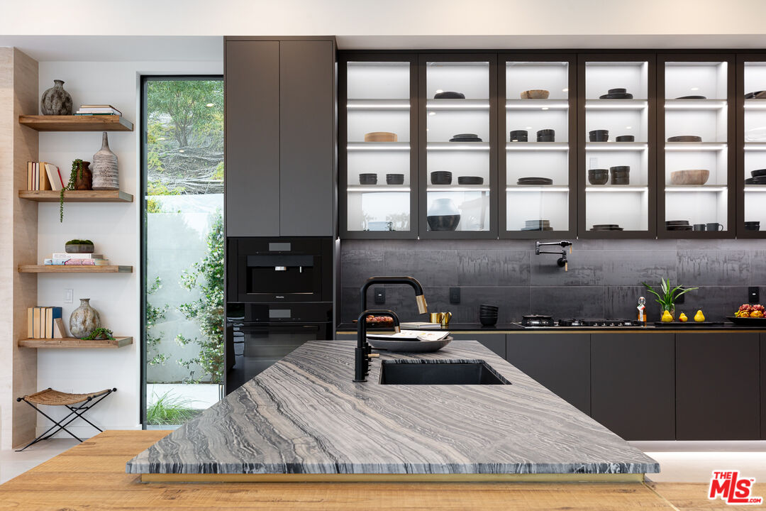 1523 Stradella Road Los Angeles, CA 90077 - Photo 30 of 54 a kitchen with granite countertop a stove a sink and a wooden cabinets