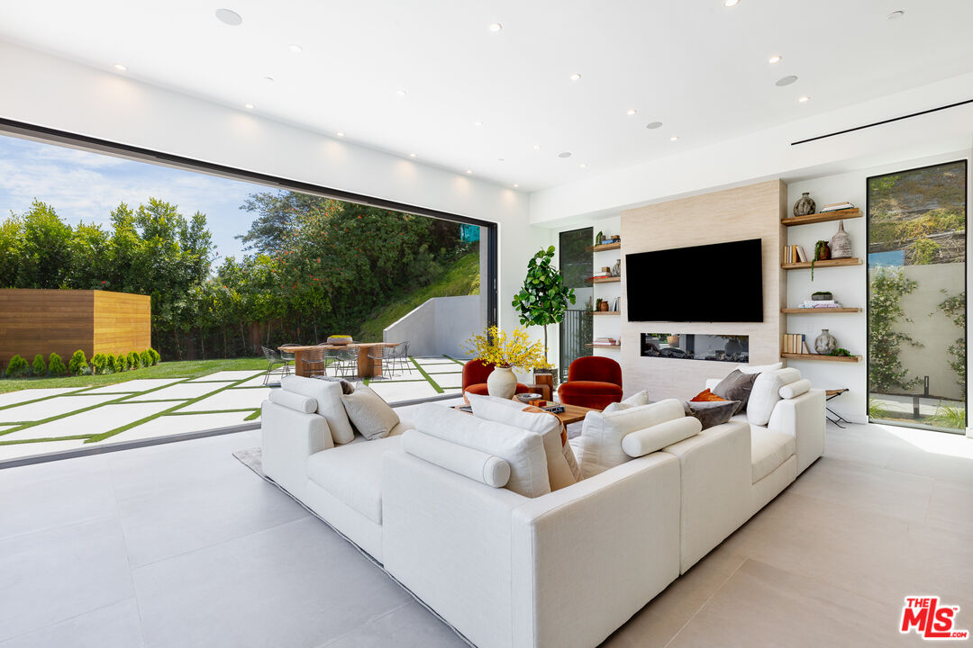 1523 Stradella Road Los Angeles, CA 90077 - Photo 33 of 54 a living room with furniture a flat screen tv and a floor to ceiling window